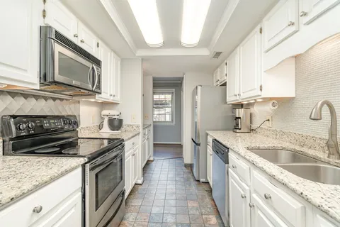 a kitchen with stainless steel appliances granite countertop a sink stove and cabinets