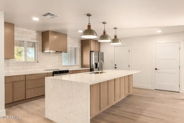 a large kitchen with a sink and dishwasher a stove with wooden floor