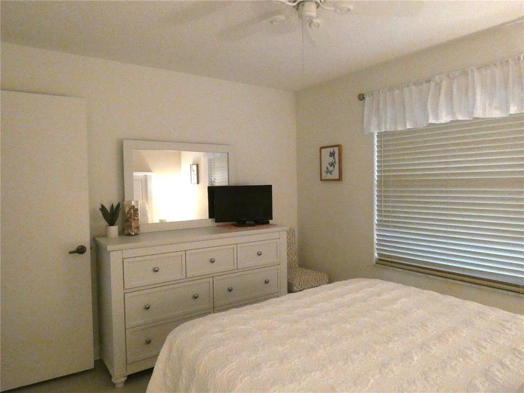 9300 Clubside Circle, Unit 1307 Sarasota, FL 34238 - Photo 18 of 40 a bedroom with a bed and a flat screen tv