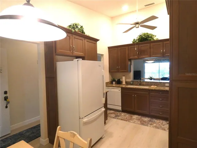 a kitchen with granite countertop a refrigerator and a stove top oven