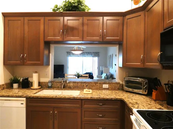 a kitchen with granite countertop wooden cabinets and a sink