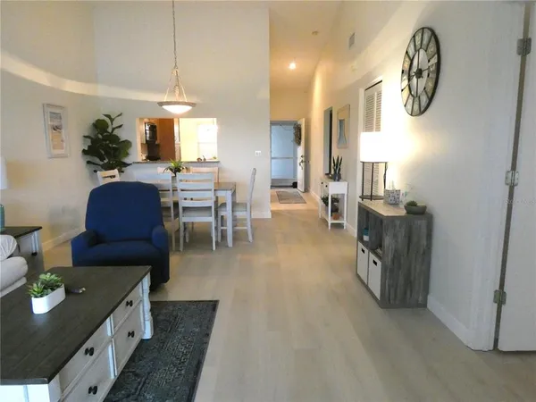 a living room with furniture a chandelier and a dining table