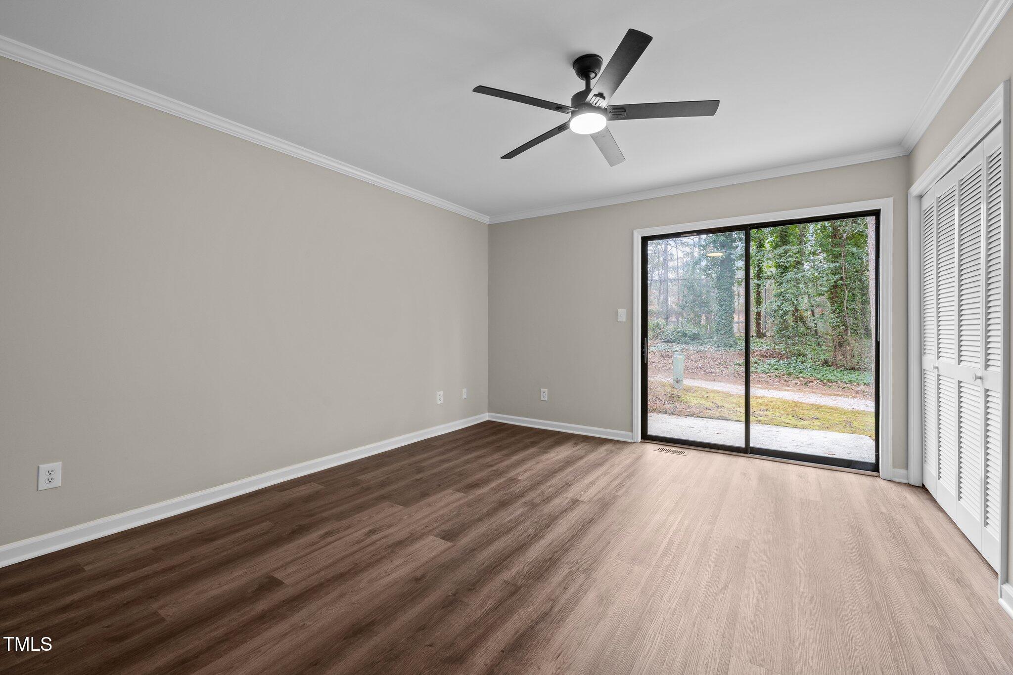 5850 Branchwood Road Raleigh, NC 27609 - Photo 13 of 27 an empty room with wooden floor fan and windows