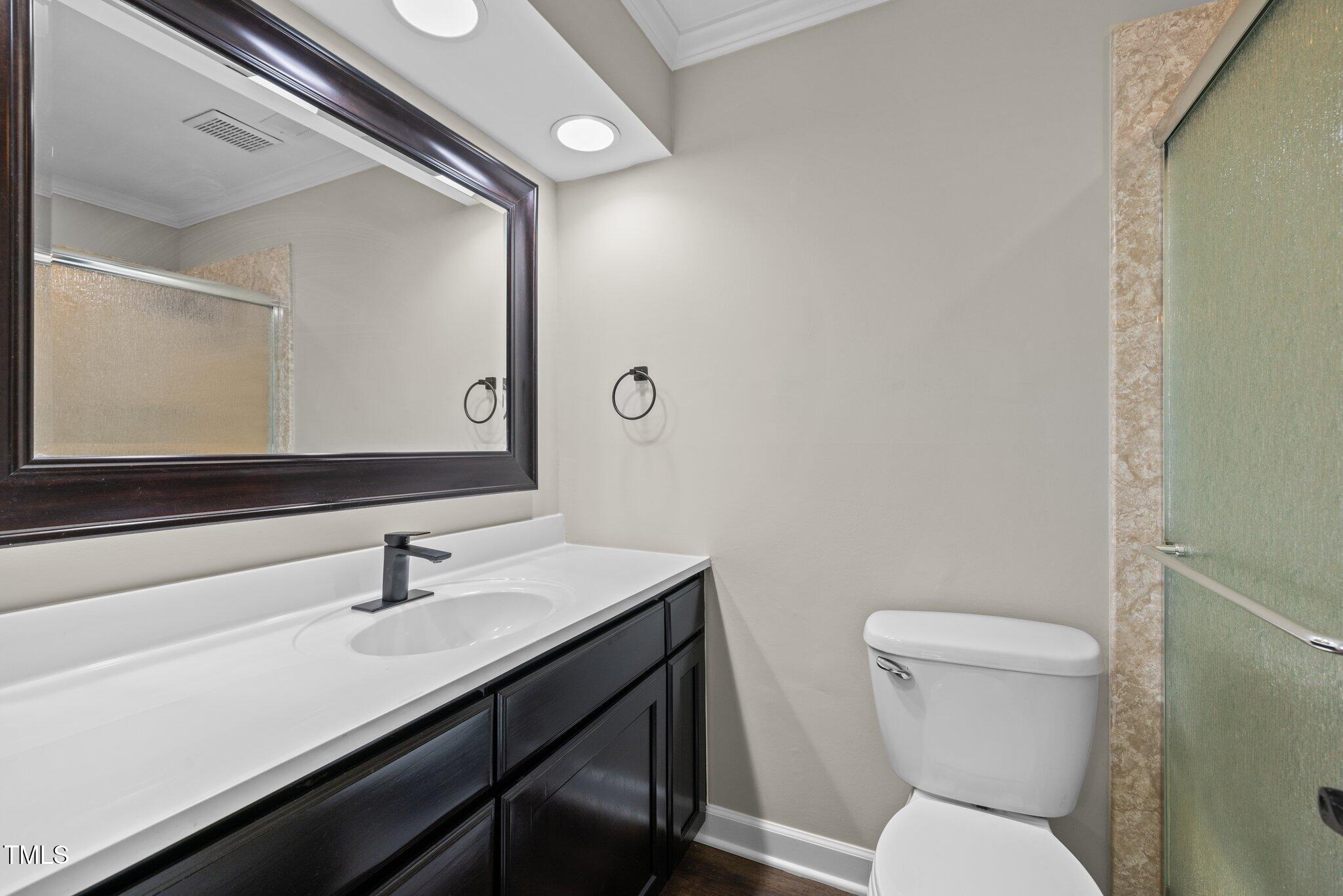 5850 Branchwood Road Raleigh, NC 27609 - Photo 16 of 27 a bathroom with a toilet a sink and mirror