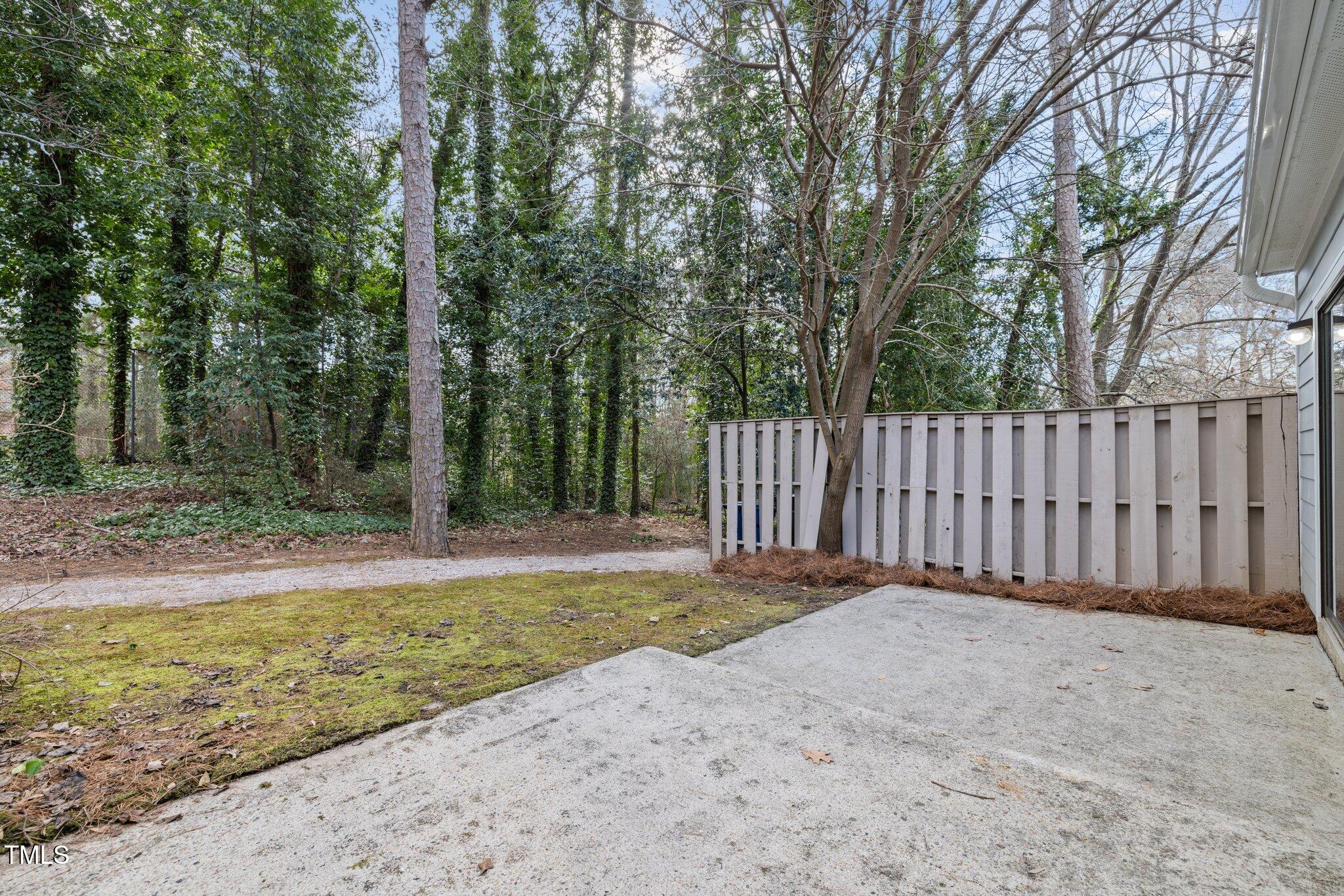 5850 Branchwood Road Raleigh, NC 27609 - Photo 20 of 27 a view of a backyard with large trees and wooden fence