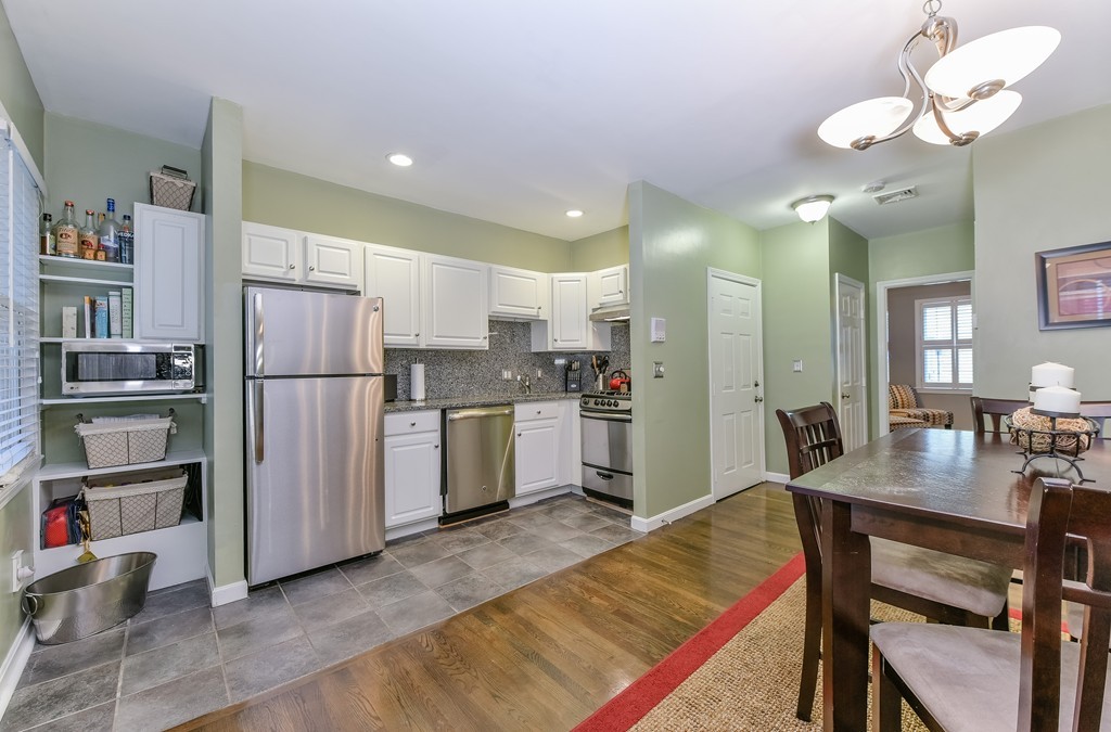 253 Gold Street, Unit 1 Boston, MA 02127 - Photo 4 of 19 a kitchen with refrigerator a sink and chairs