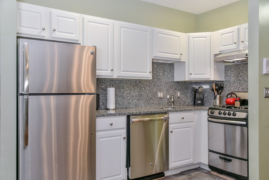 253 Gold Street, Unit 1 Boston, MA 02127 - Photo 5 of 19 a kitchen with stainless steel appliances granite countertop a refrigerator sink and cabinets