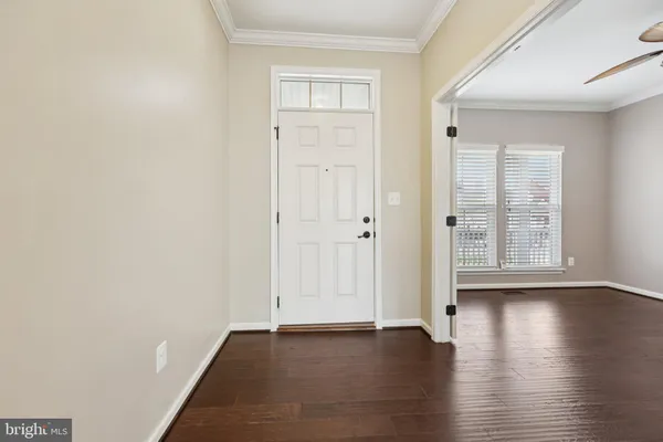 a kitchen with stainless steel appliances granite countertop a refrigerator a sink dishwasher a stove and white cabinets with wooden floor