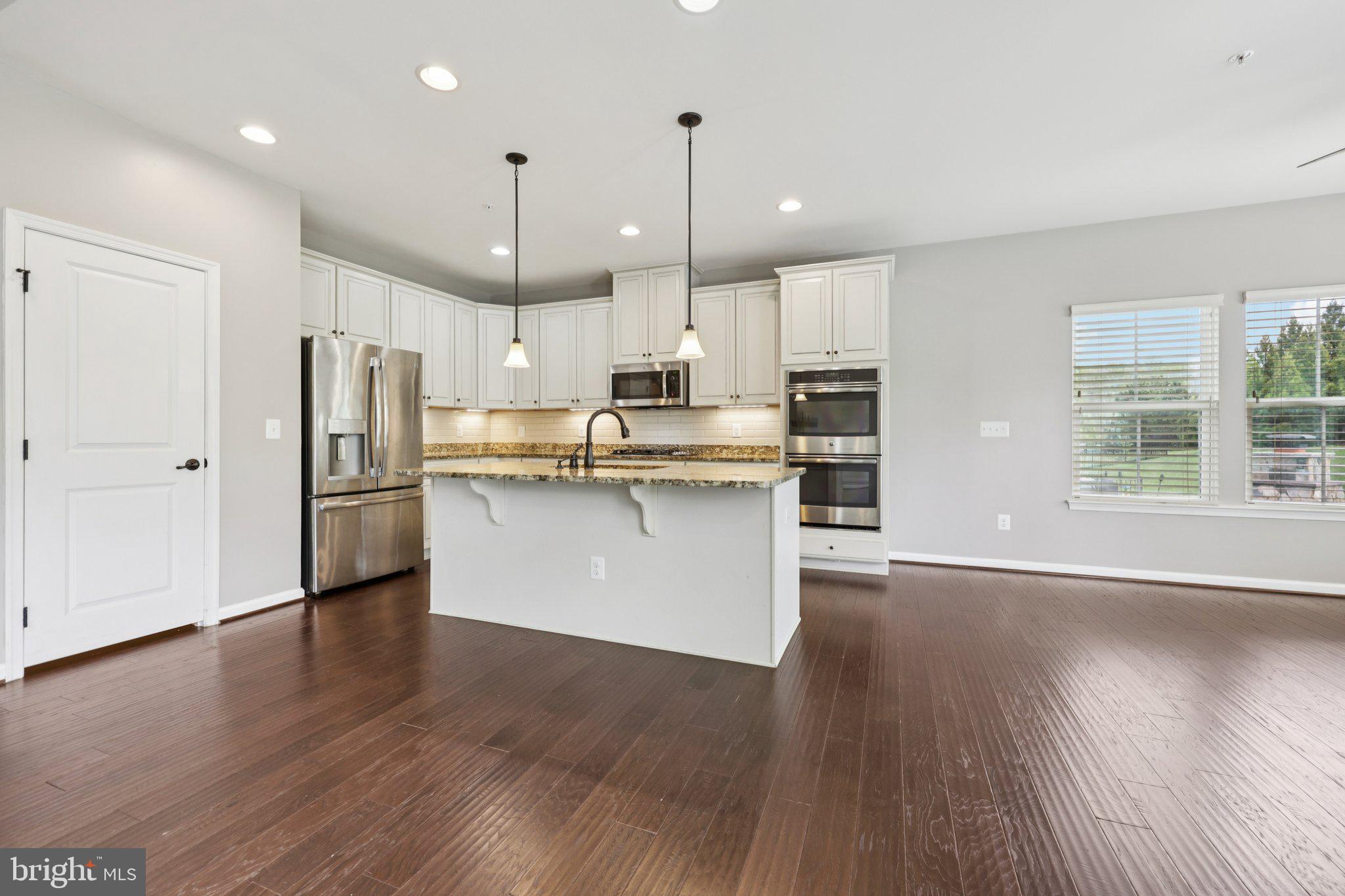 17518 Spring Cress Drive Dumfries, VA 22026 - Photo 24 of 89 a kitchen with stainless steel appliances granite countertop a refrigerator a sink dishwasher a stove and white cabinets with wooden floor