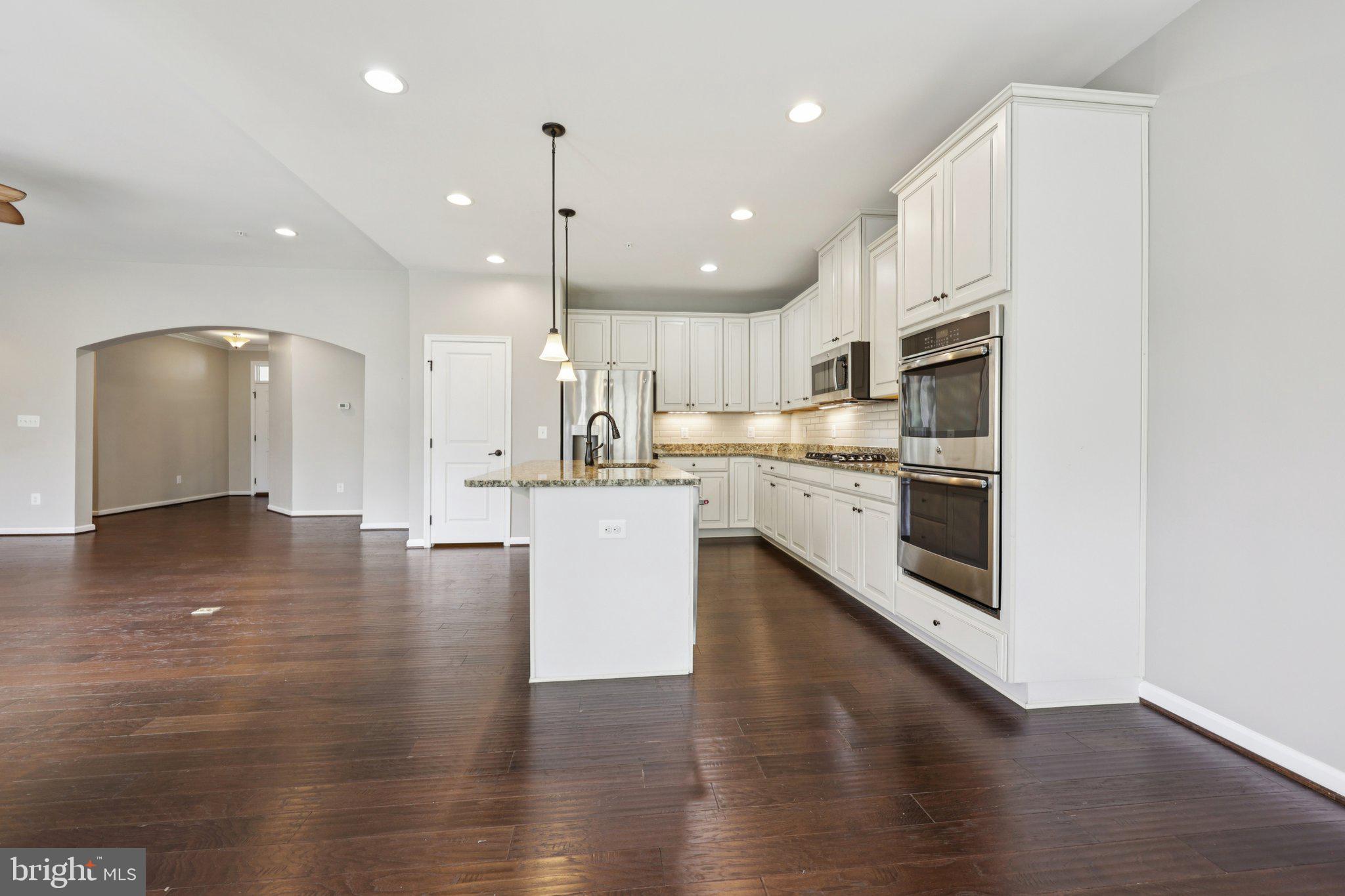 17518 Spring Cress Drive Dumfries, VA 22026 - Photo 26 of 89 a kitchen with kitchen island a white counter top space cabinets and stainless steel appliances