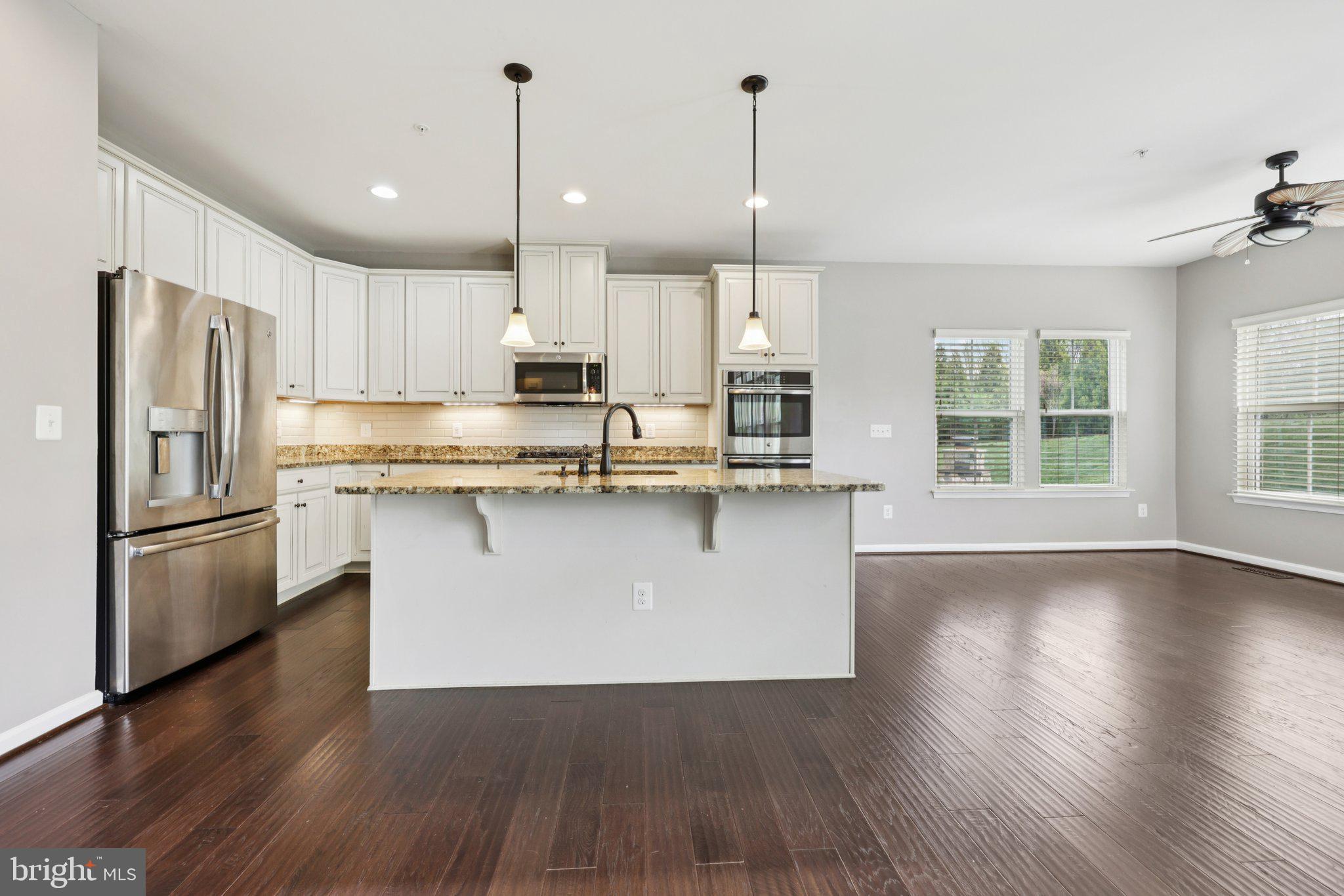 17518 Spring Cress Drive Dumfries, VA 22026 - Photo 28 of 89 a kitchen with stainless steel appliances granite countertop a refrigerator a sink dishwasher a stove and white cabinets with wooden floor