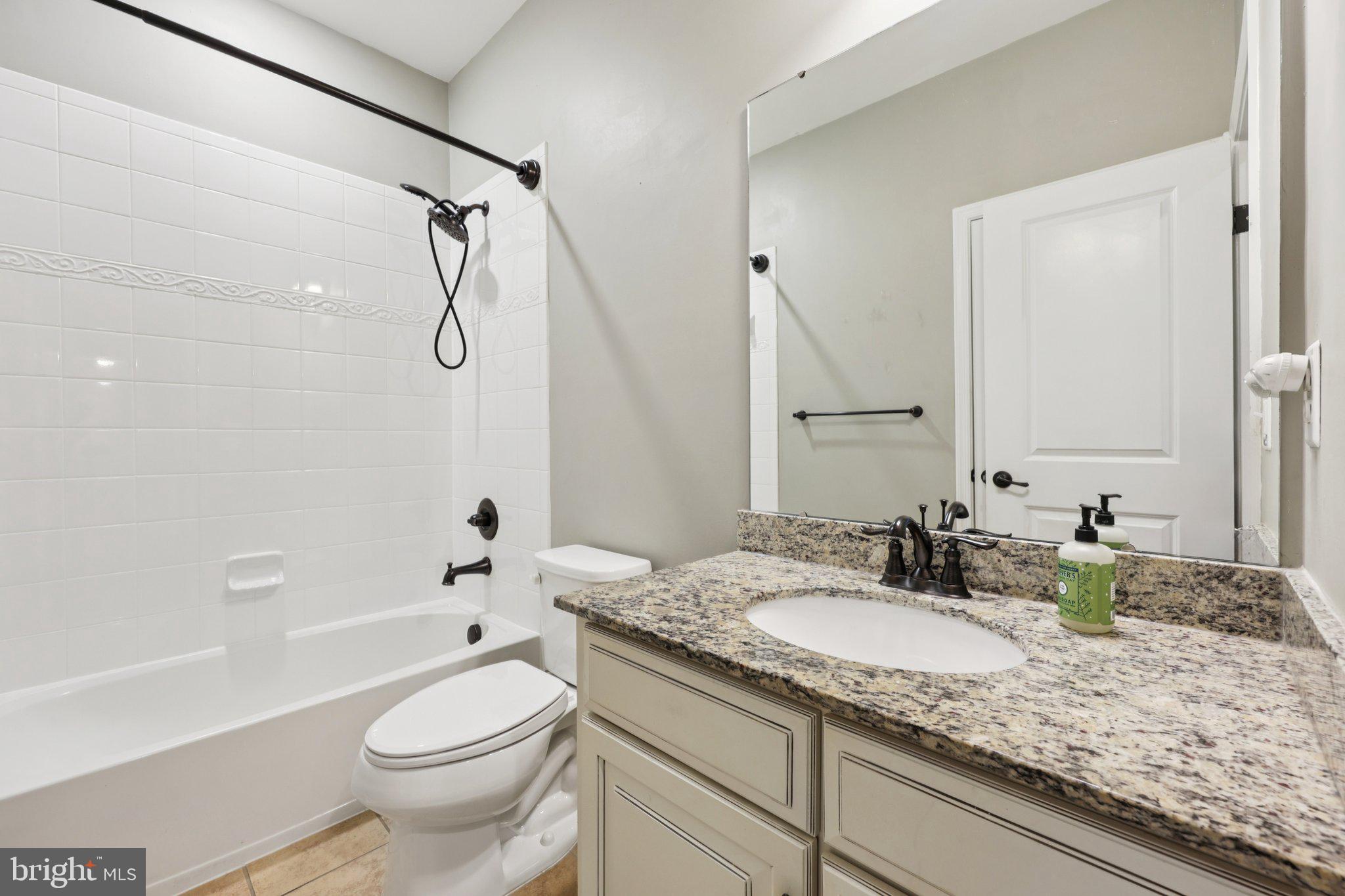 17518 Spring Cress Drive Dumfries, VA 22026 - Photo 69 of 89 a bathroom with a granite countertop sink toilet mirror and bathtub