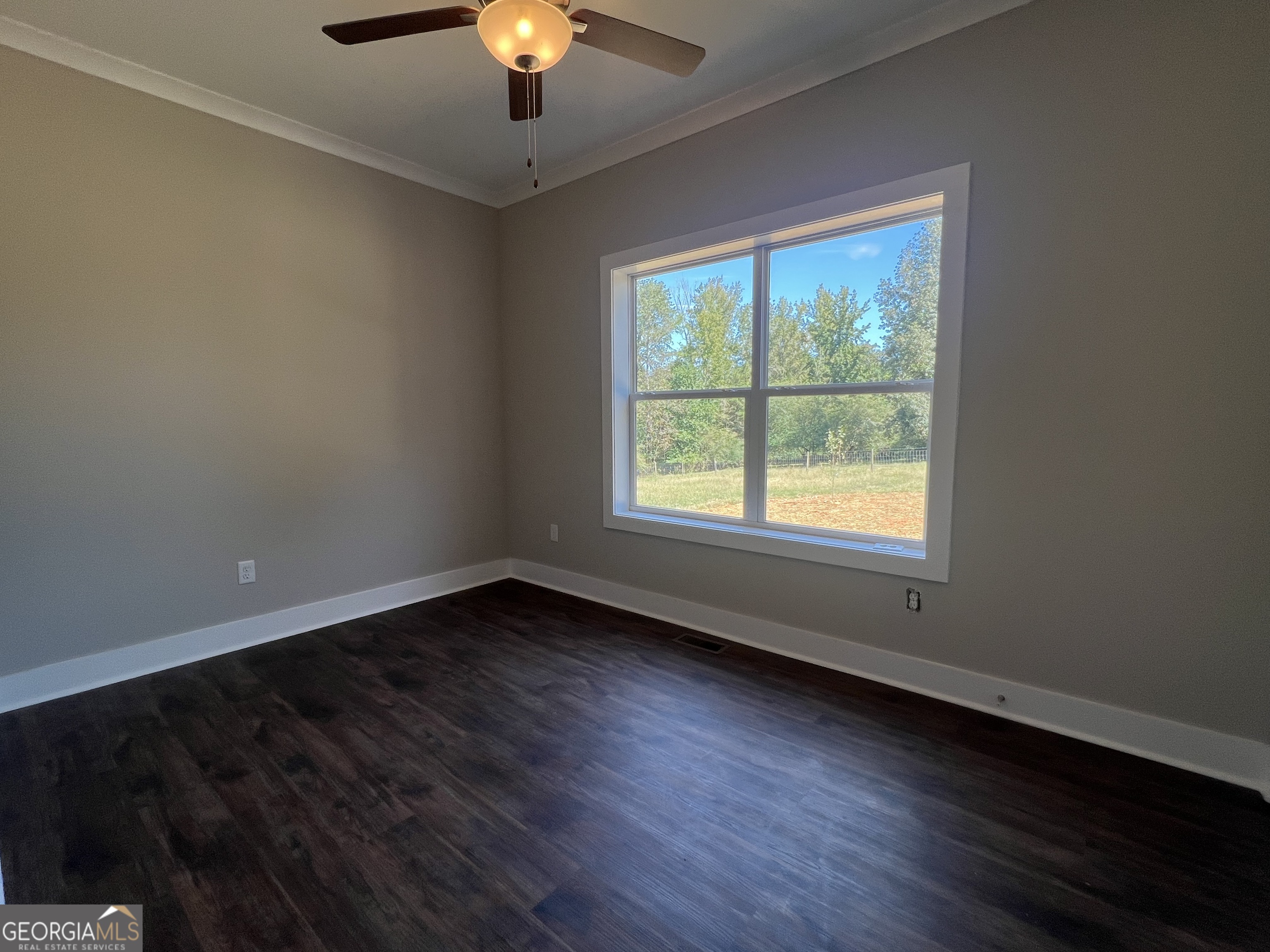 195 Cedar Road Covington, GA 30016 - Photo 9 of 19 a view of an empty room with wooden floor and a window