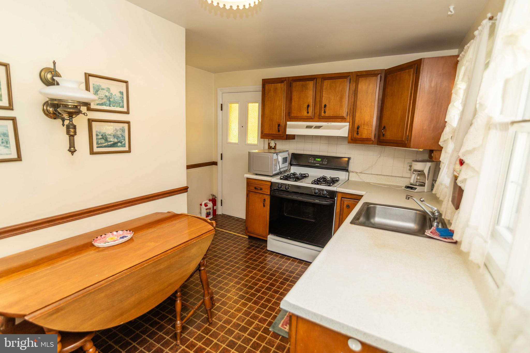 704 Hood Road Swarthmore, PA 19081 - Photo 8 of 34 a kitchen with wooden cabinets a sink a stove and a refrigerator