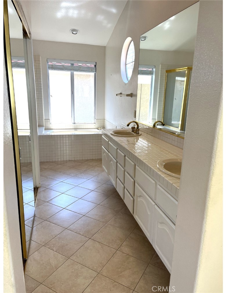 23 San Raphael Dana Point, CA 92629 - Photo 14 of 24 a bathroom with a double vanity sink mirror bathtub and window