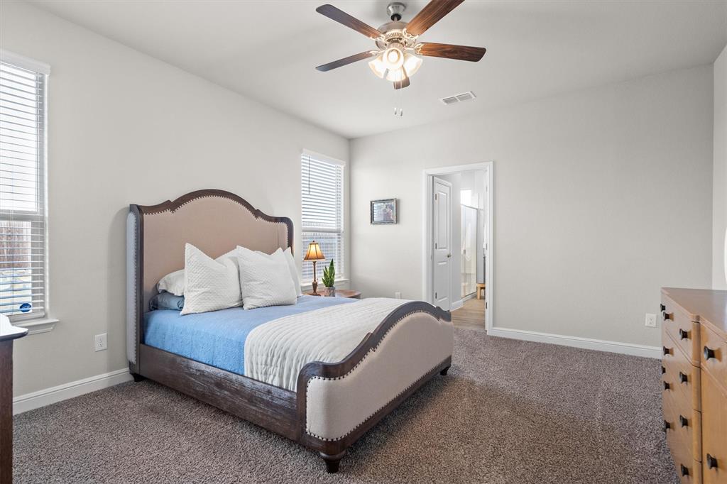 1864 Mensa Drive Haslet, TX 76052 - Photo 24 of 40 a bedroom with a bed and a chandelier