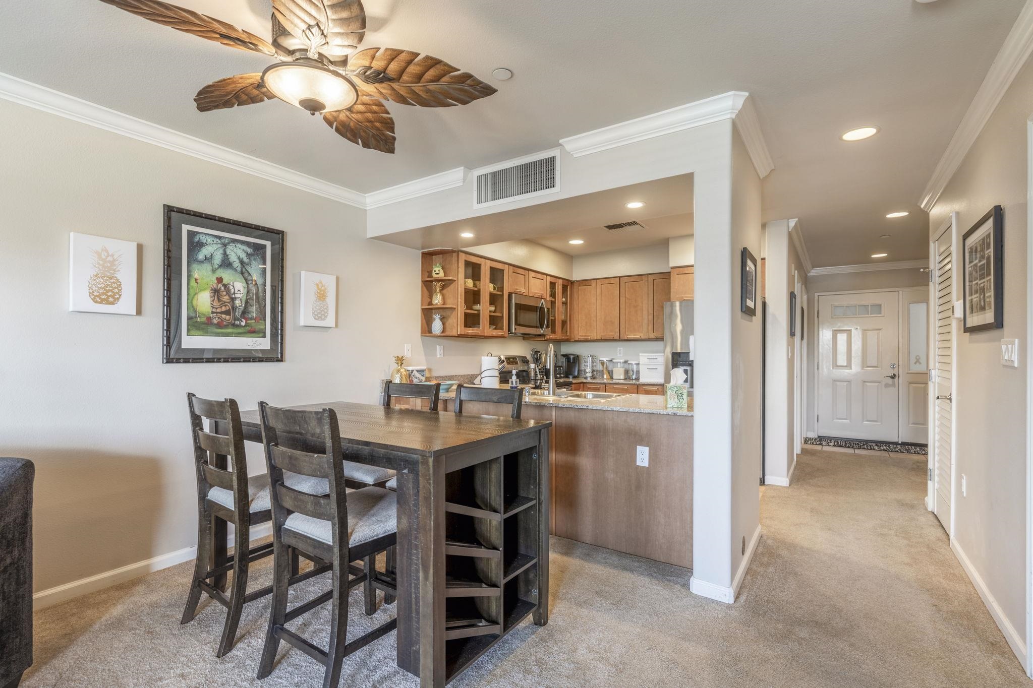 44 Kanani Road, Unit 2202 Kihei, HI 96753 - Photo 11 of 42 a kitchen with a dining table chairs cabinets and stainless steel appliances