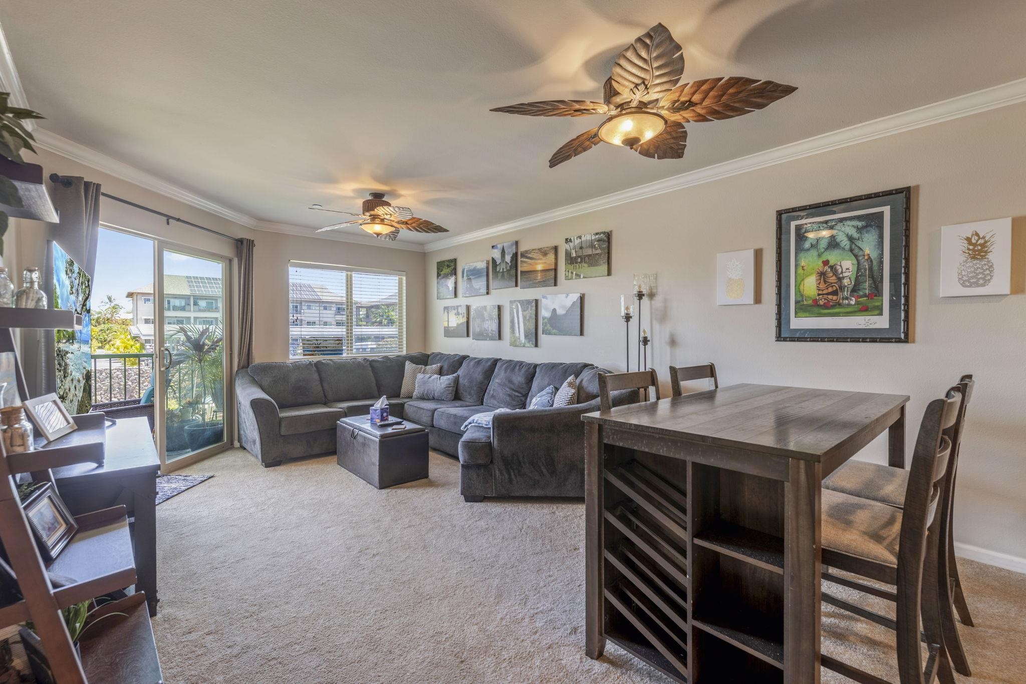 44 Kanani Road, Unit 2202 Kihei, HI 96753 - Photo 14 of 42 a living room with furniture a chandelier a large window and a flat screen tv