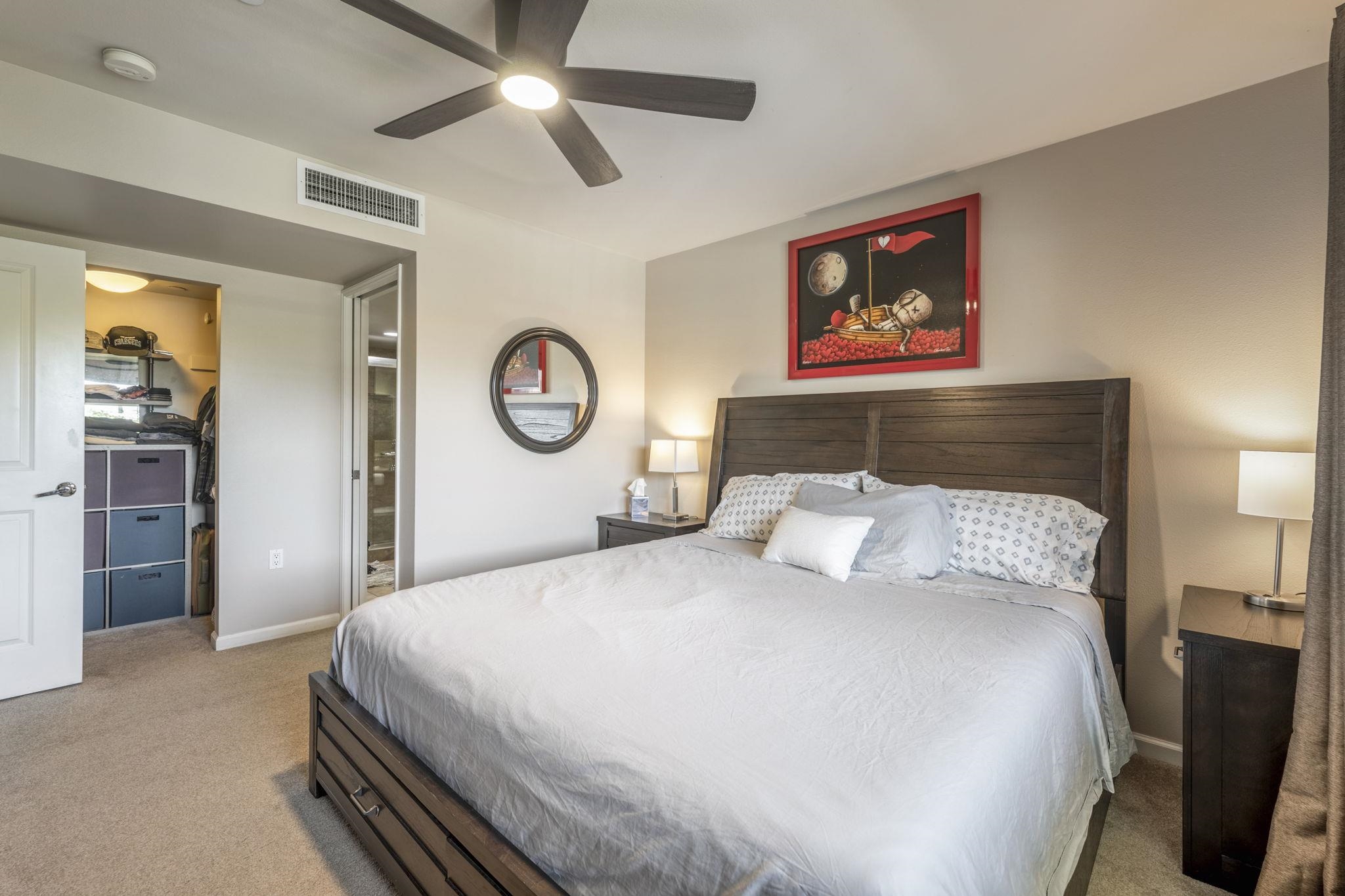 44 Kanani Road, Unit 2202 Kihei, HI 96753 - Photo 16 of 42 a bedroom with a large bed and a chandelier