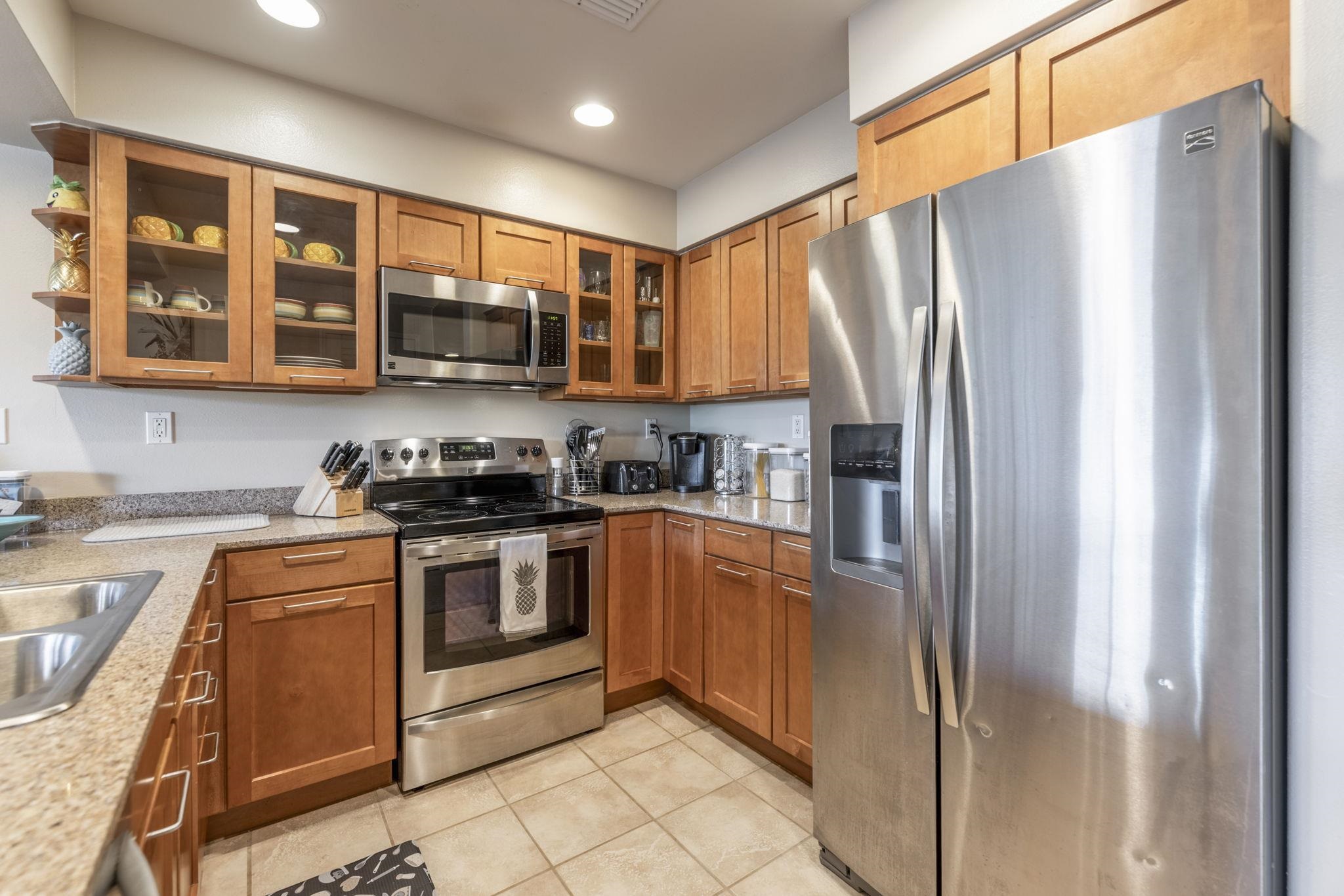44 Kanani Road, Unit 2202 Kihei, HI 96753 - Photo 8 of 42 a kitchen with stainless steel appliances granite countertop a refrigerator and a stove top oven