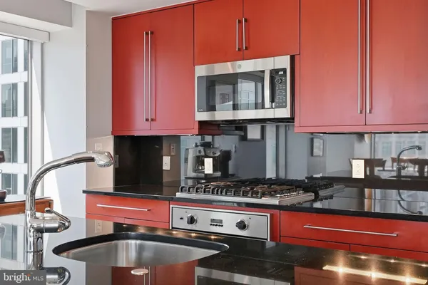 a kitchen with granite countertop a stove and a microwave