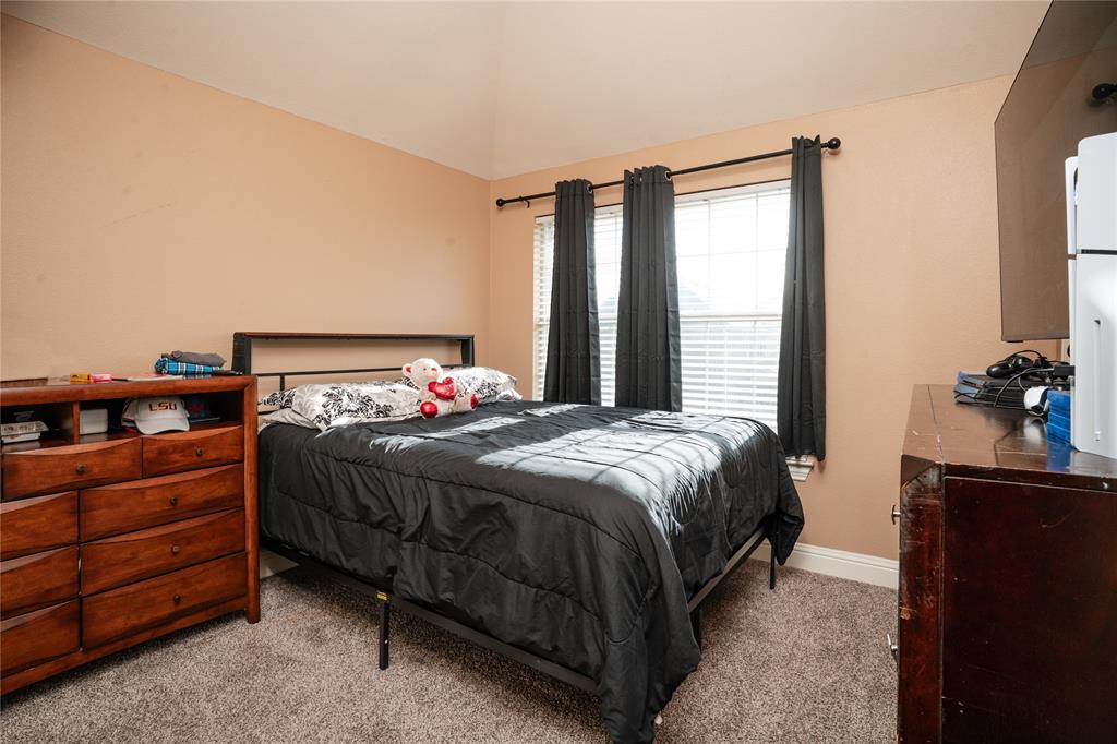 1444 Mercury Lane Lancaster, TX 75134 - Photo 18 of 19 a bedroom with a bed and a flat tv screen on dresser