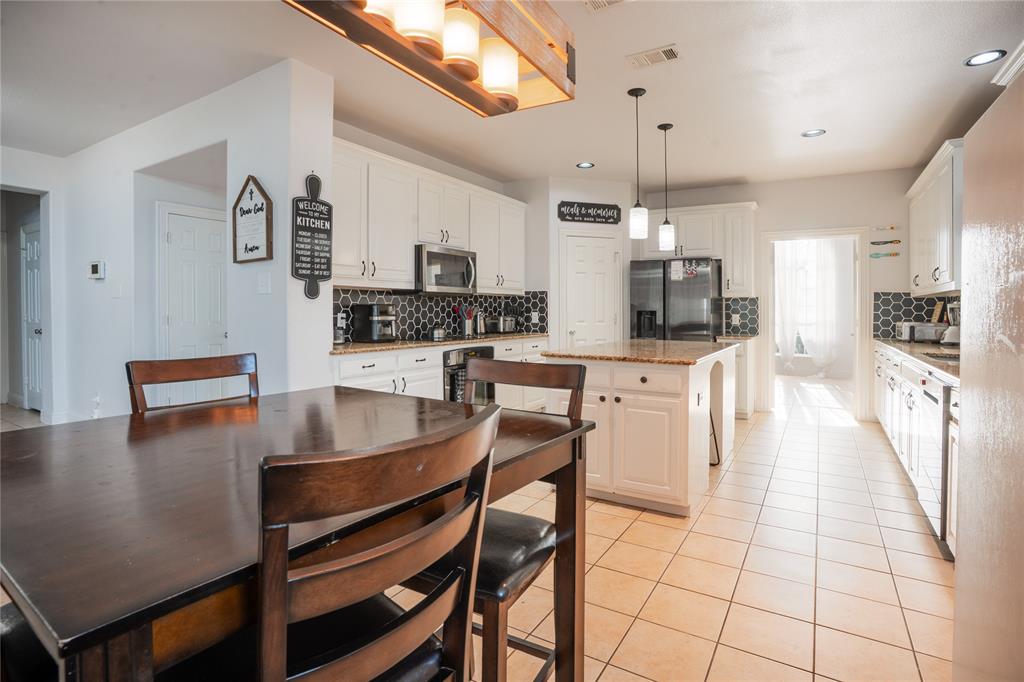 1444 Mercury Lane Lancaster, TX 75134 - Photo 6 of 19 a kitchen with stainless steel appliances kitchen island granite countertop a sink a stove a table and chairs