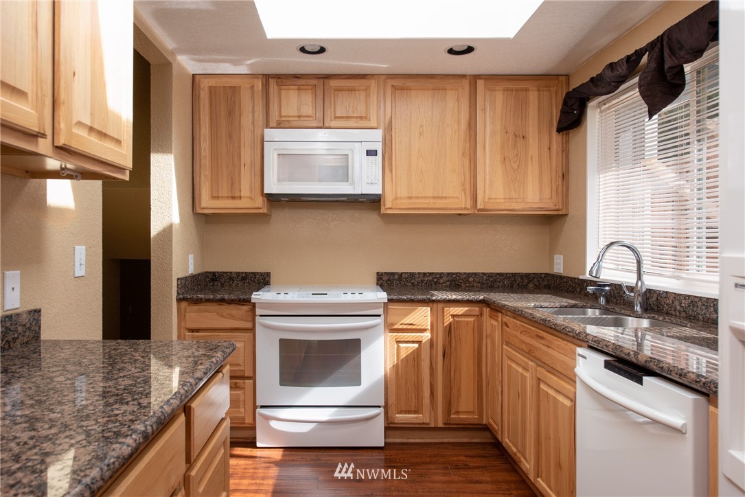 220 154th Place Southeast Bothell, WA 98012 - Photo 8 of 25 a kitchen with granite countertop a sink stove and cabinets