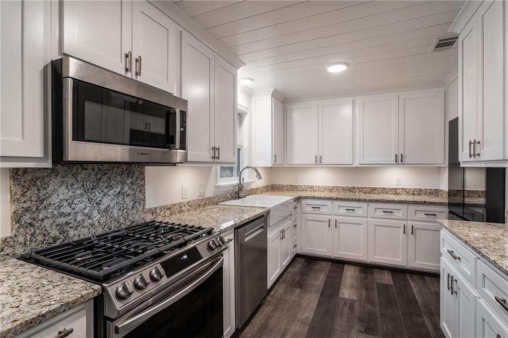 9351 Henderson Mountain Road Fairmount, GA 30139 - Photo 19 of 60 a kitchen with stainless steel appliances granite countertop a stove and a microwave