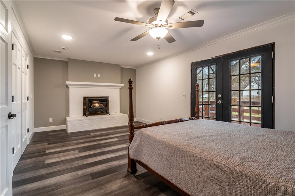 9351 Henderson Mountain Road Fairmount, GA 30139 - Photo 26 of 60 a spacious bedroom with a bed and a fireplace
