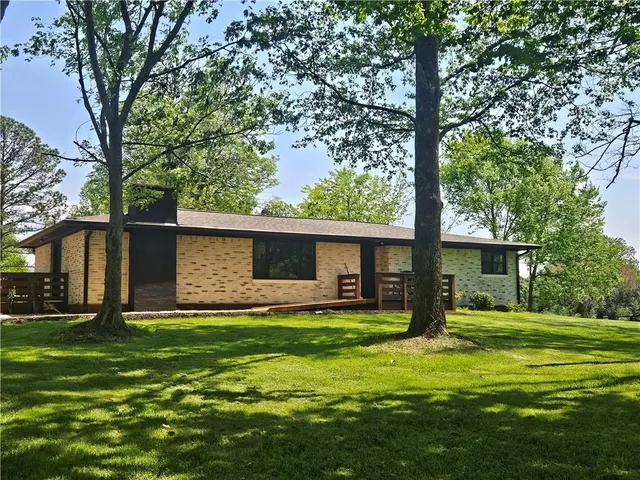 a backyard of a house with barbeque oven and wooden wall