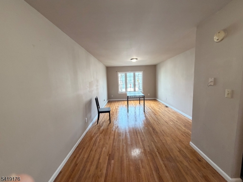 1036 Flora Street, Unit 1 Elizabeth, NJ 07201 - Photo 2 of 10 a view of empty room with wooden floor and fan