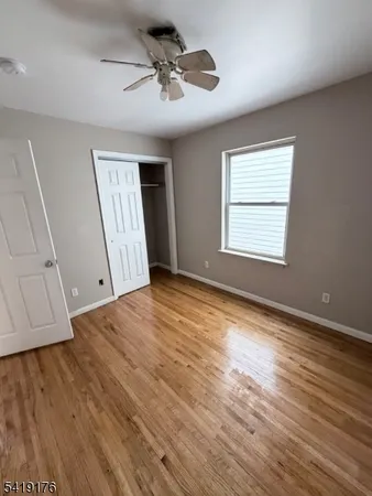 an empty room with wooden floor and window