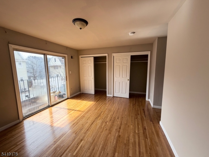 1036 Flora Street, Unit 1 Elizabeth, NJ 07201 - Photo 7 of 10 a view of empty room with wooden floor and fan