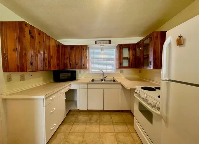 a living room with furniture and a dining table with chandelier
