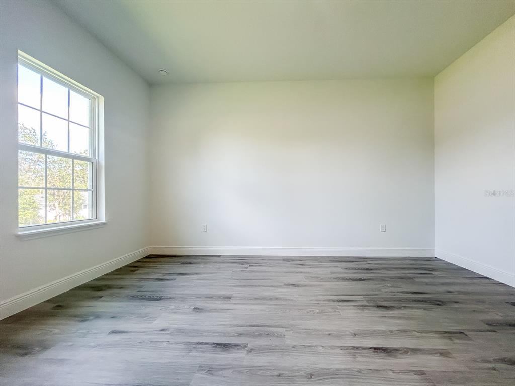 3159 Southwest 127th Lane Road Ocala, FL 34473 - Photo 11 of 32 a view of an empty room with wooden floor and a window