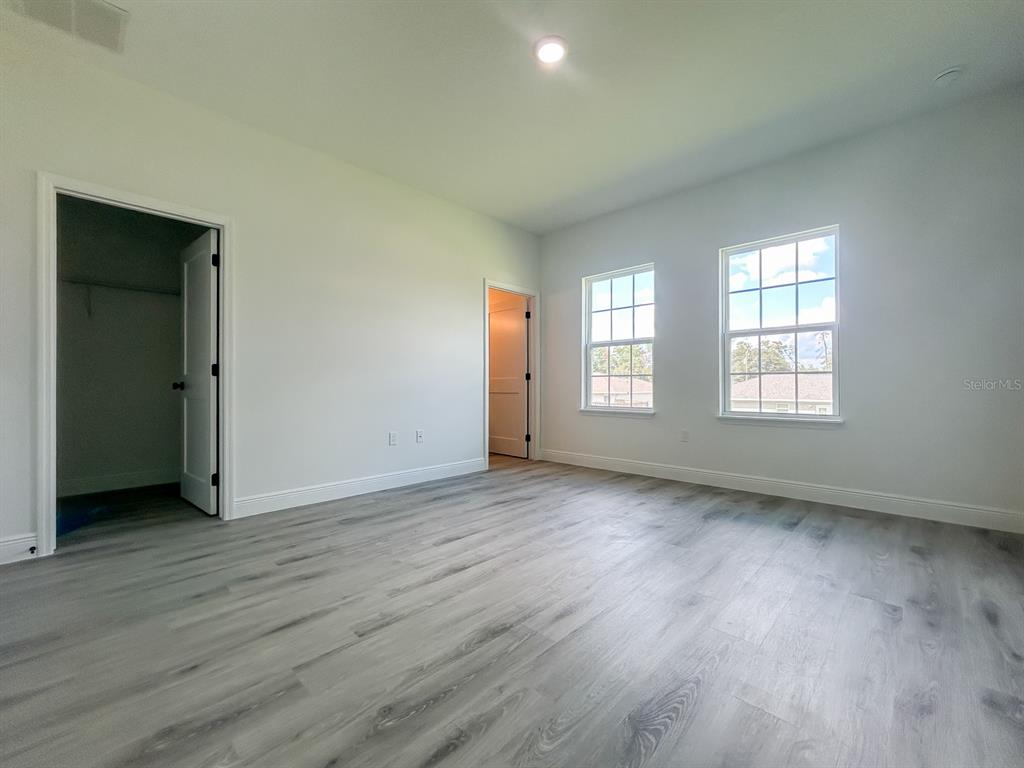 3159 Southwest 127th Lane Road Ocala, FL 34473 - Photo 12 of 32 an empty room with wooden floor and windows