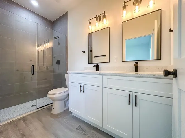 a bathroom with a sink a toilet and a mirror