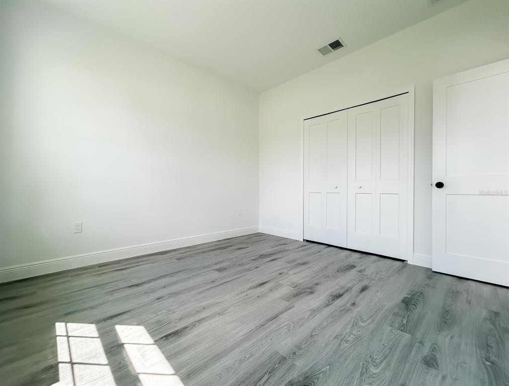 3159 Southwest 127th Lane Road Ocala, FL 34473 - Photo 21 of 32 a view of an empty room with wooden floor and a window