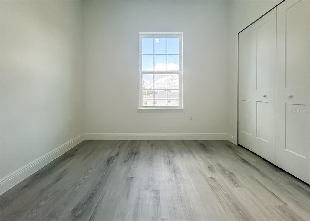 3159 Southwest 127th Lane Road Ocala, FL 34473 - Photo 24 of 32 an empty room with wooden floor and windows