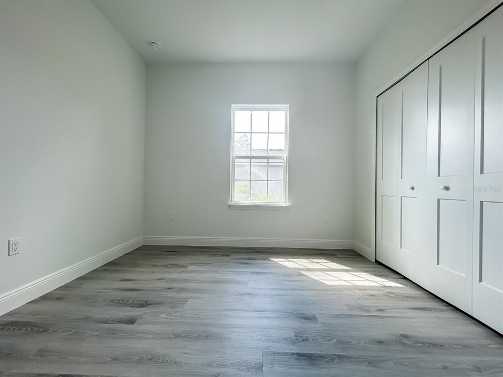 3159 Southwest 127th Lane Road Ocala, FL 34473 - Photo 29 of 32 an empty room with wooden floor and windows