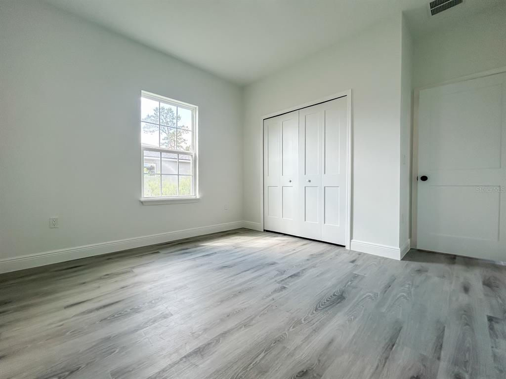 3159 Southwest 127th Lane Road Ocala, FL 34473 - Photo 30 of 32 an empty room with wooden floor and windows