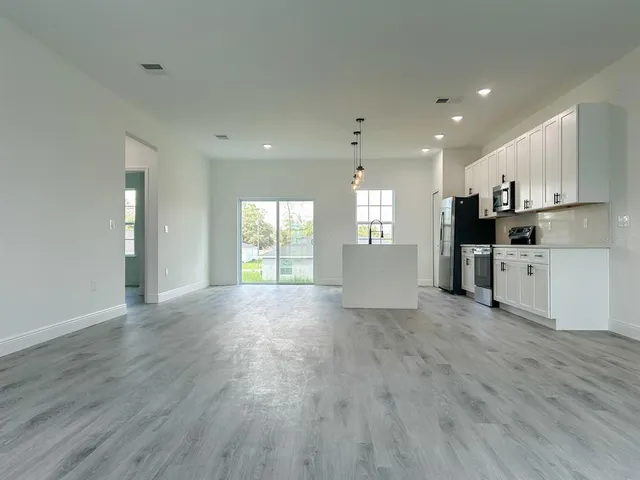 a view of a kitchen with a sink and wooden floor
