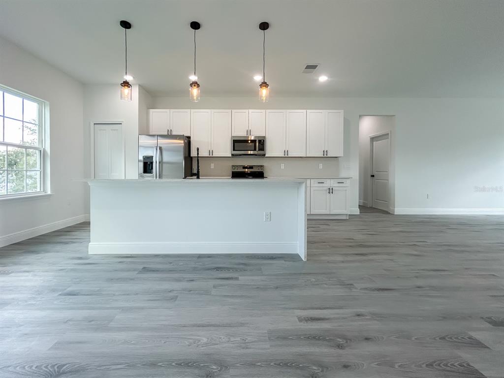 3159 Southwest 127th Lane Road Ocala, FL 34473 - Photo 6 of 32 a view of a kitchen with kitchen island a sink stainless steel appliances and cabinets