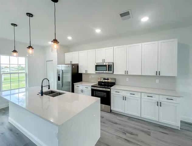 a view of a kitchen with wooden floor and a sink