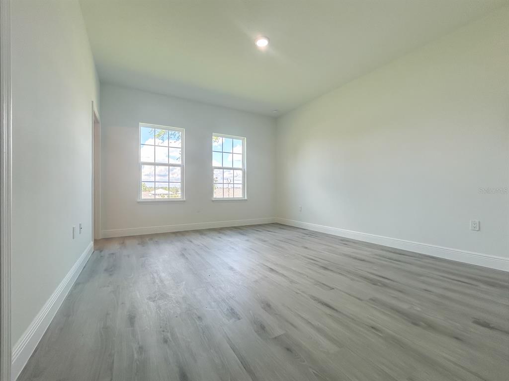 3159 Southwest 127th Lane Road Ocala, FL 34473 - Photo 10 of 32 an empty room with wooden floor and windows