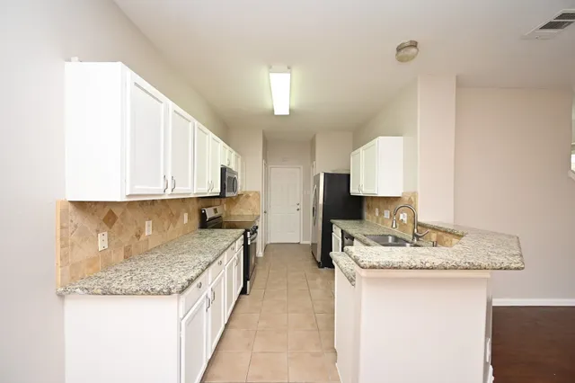 a kitchen with a sink stove and cabinets