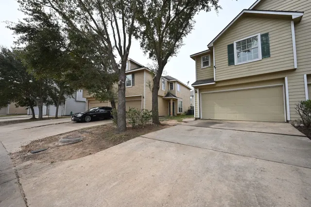 a view of a white house with a large tree
