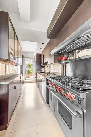 a large kitchen with stainless steel appliances a large counter top