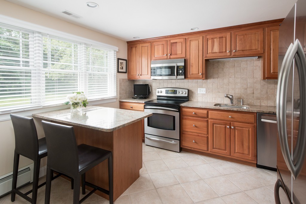21 Spruce Road Medway, MA 02053 - Photo 11 of 26 a kitchen with stainless steel appliances granite countertop a stove a sink a microwave and a refrigerator